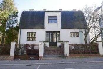 Casa Steiner (Adolf Loos): Una grande casa bianca con un tetto scuro ad arco.
