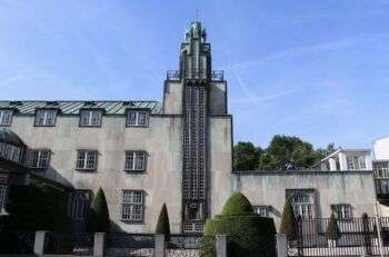 Bruxelles - Palais Stoclet : Un grand bâtiment simpliste aux accents de métal vert, trois étages et une tour au centre.