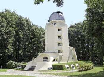 The Einstein Tower located in Potsdam, Germany: A tall skinny white tower with a grey, dome roof. 