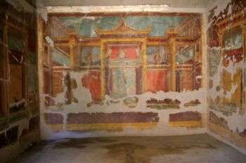 Villa de Popea (Oplontis): Wall painting of a temple. Various vivid blues, reds and golds cover the wall. The paint is fading off as well.