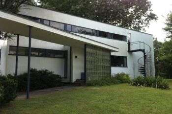 Walter Gropius' House: A simple white house with a metal, swirly staircase along the outside. 