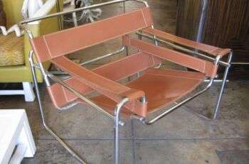 Wassily Chair: A metal chair with orange/brown fabric accents. 