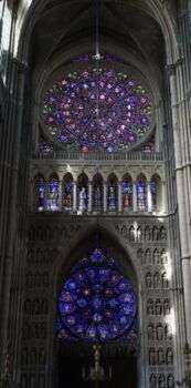 A photo of Rose Windows, or spiral stained-glass windows in the Reims Cathedral in France.
