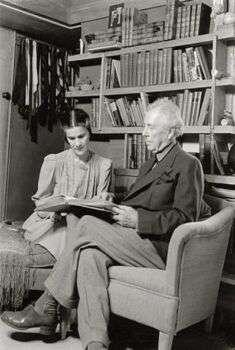 Frank Lloyd Wright and his wife (1936): A photo of Wright on the right and his wife on the left, they are looking at a book together.