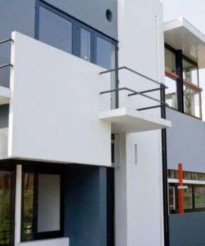 Schroder House by Gerrit Rietveld: A simple, white structure with 2 balconies along the front. 
